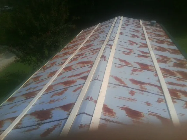 Rusted metal roof panels with new wood purlins before replacement — Storm Damage Roof Repair in Woodlawn by Roofing Brothers
