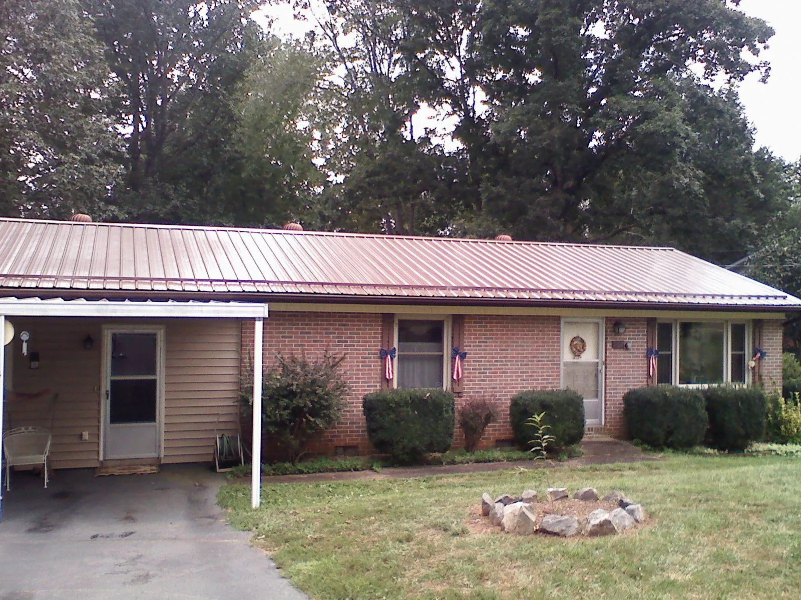 Bronze metal roof and carport on a brick ranch home — Roof Repair work by our crew in Woodlawn